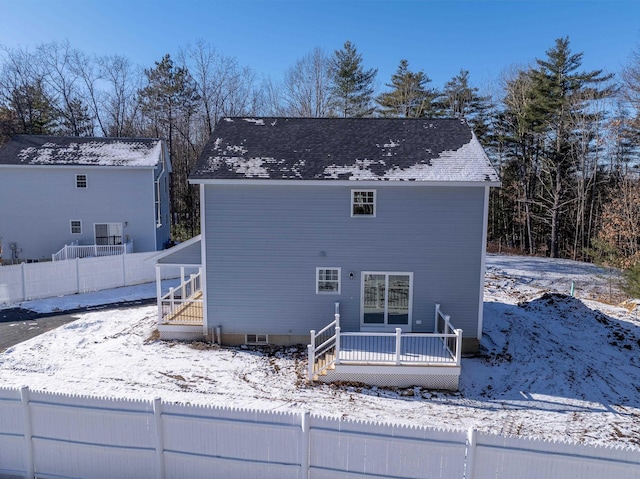 snow covered house with a deck