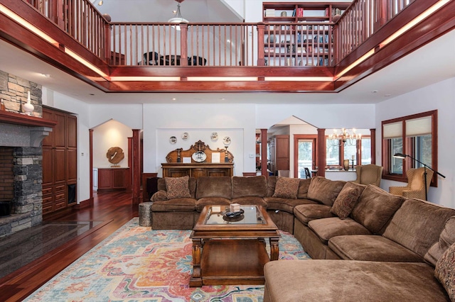 51 E Ash Rd, Plymouth, VT 05056 - living room with dark hardwood / wood-style flooring, ornate columns, an inviting chandelier, a fireplace, and a high ceiling