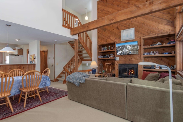 360 Okemo Trailside Ext Unit 37C, Ludlow, VT 05149 - carpeted living area with a towering ceiling, wood walls, stairway, and a glass covered fireplace