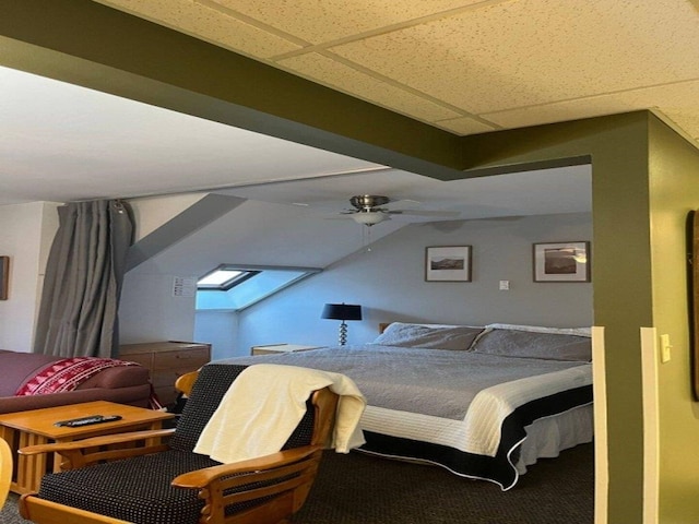 carpeted bedroom with a paneled ceiling and ceiling fan