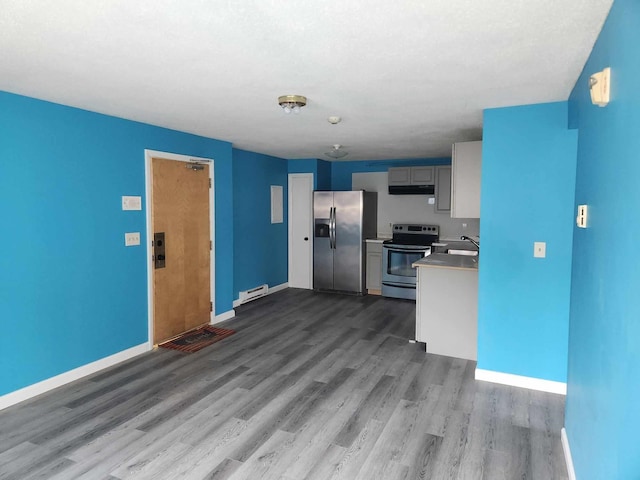 kitchen with gray cabinetry, wood-type flooring, a baseboard radiator, stainless steel appliances, and sink