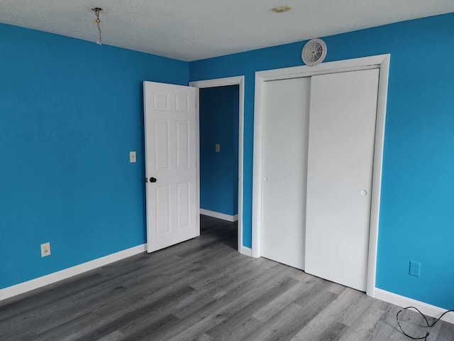 unfurnished bedroom featuring a closet and wood-type flooring