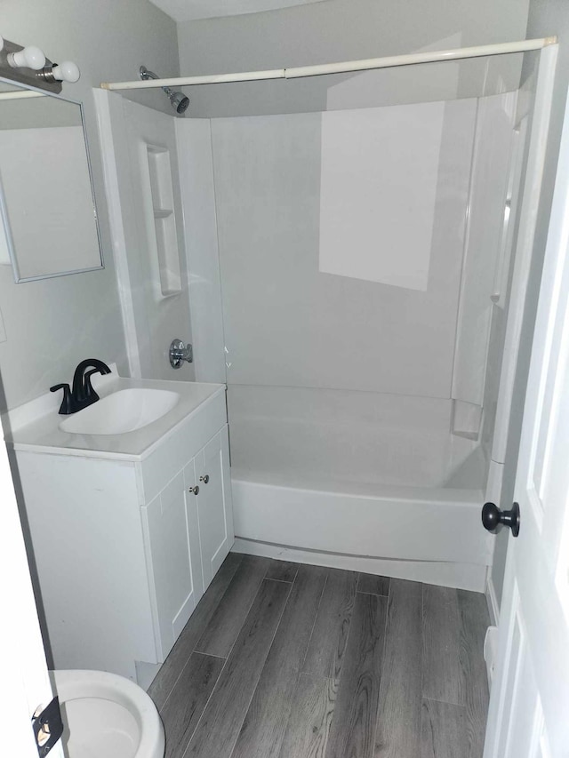 bathroom with hardwood / wood-style floors, shower / washtub combination, and vanity