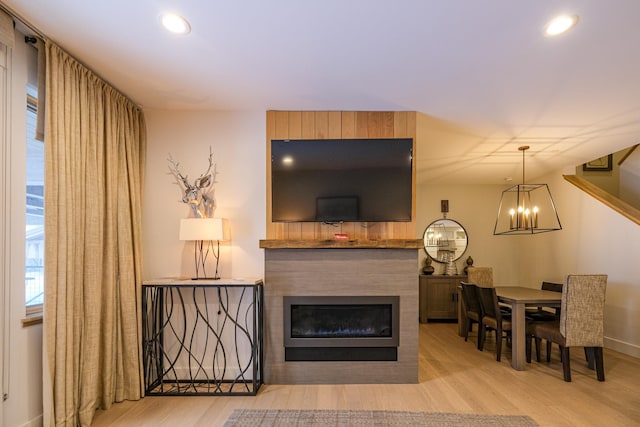 living room featuring a notable chandelier and light wood-type flooring