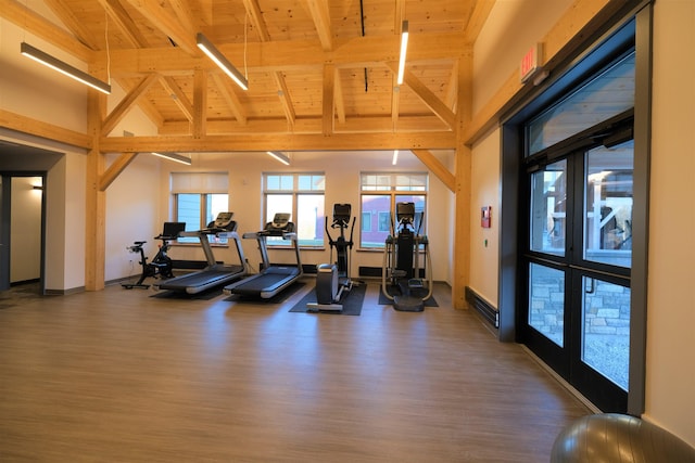 exercise room with dark wood-type flooring, high vaulted ceiling, french doors, and wooden ceiling