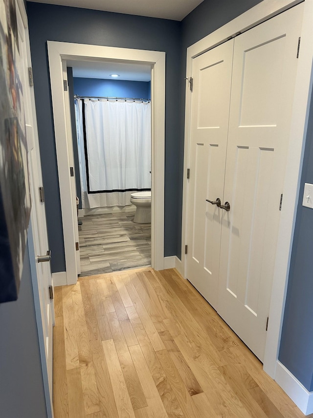 corridor with light hardwood / wood-style floors