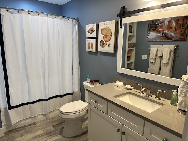 bathroom with a shower with shower curtain, vanity, hardwood / wood-style flooring, and toilet