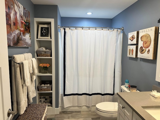 bathroom with hardwood / wood-style floors, vanity, toilet, and curtained shower