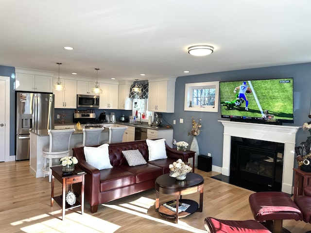 living room featuring sink and light hardwood / wood-style flooring