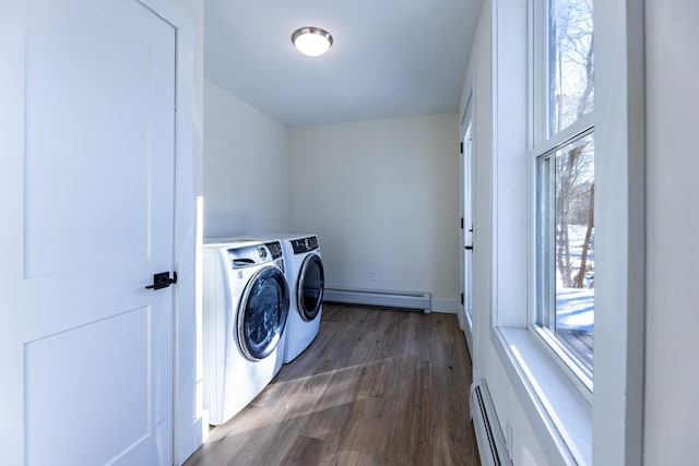 laundry area featuring washing machine and clothes dryer, dark hardwood / wood-style floors, and a baseboard heating unit