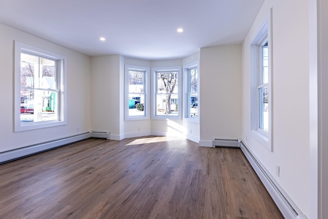 unfurnished room with dark hardwood / wood-style floors, a baseboard radiator, and plenty of natural light