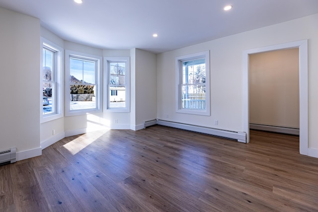 empty room with a baseboard radiator and dark hardwood / wood-style floors