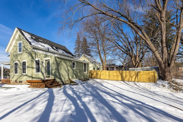 view of snow covered rear of property