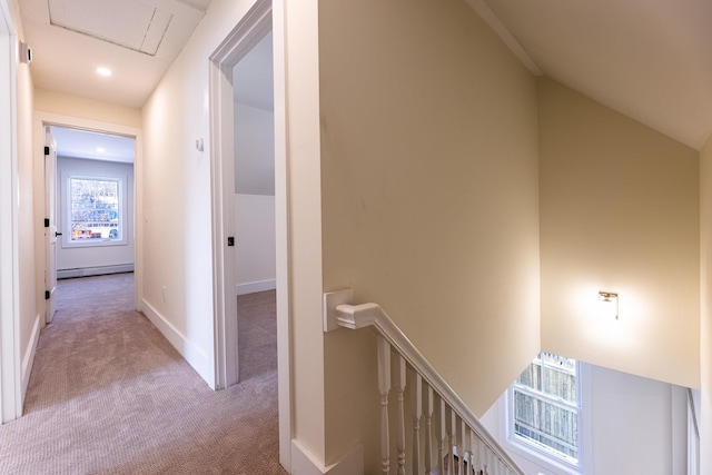 corridor featuring light colored carpet, baseboard heating, and lofted ceiling