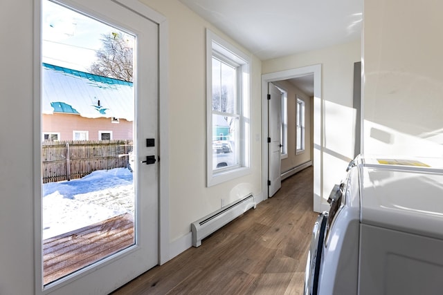 doorway to outside featuring washer / dryer, dark hardwood / wood-style floors, and a baseboard heating unit