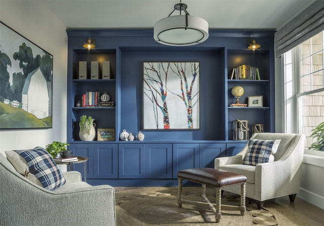 living area featuring built in shelves and wood-type flooring