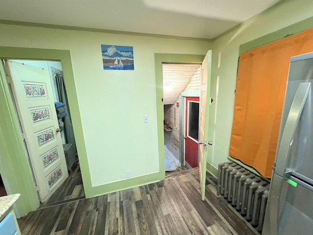 hall featuring radiator heating unit, dark wood-type flooring, and vaulted ceiling