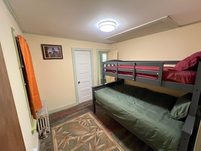 bedroom featuring radiator heating unit, dark hardwood / wood-style flooring, and crown molding