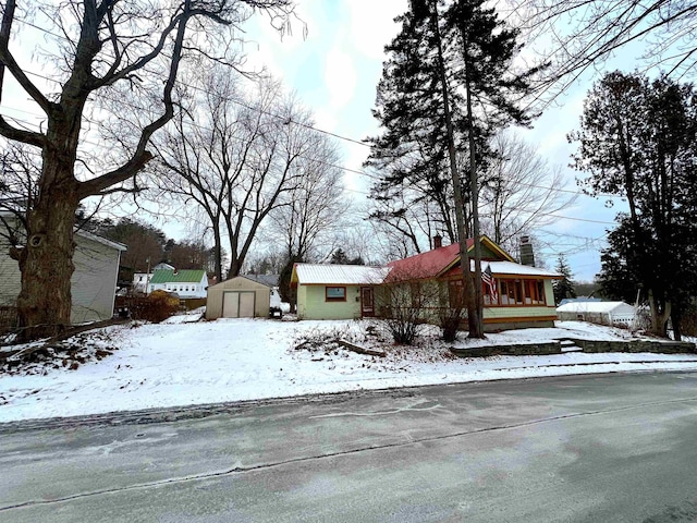 view of front of home featuring a garage and an outbuilding