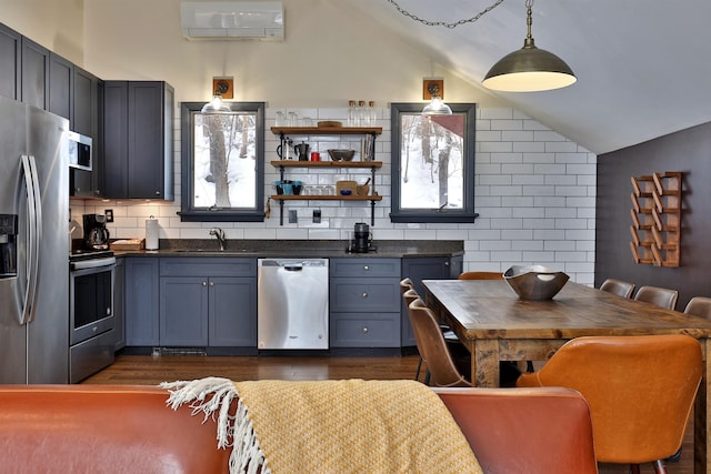 kitchen with lofted ceiling, sink, a wall mounted air conditioner, and appliances with stainless steel finishes