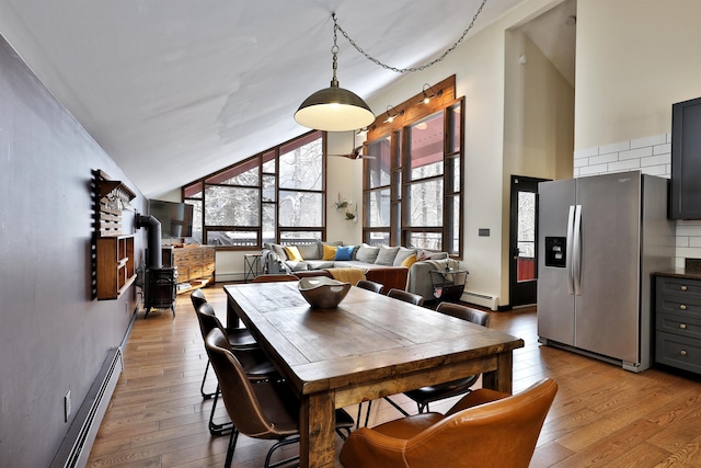 dining room featuring plenty of natural light, light hardwood / wood-style floors, and a baseboard radiator