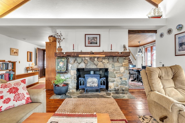 living room featuring beam ceiling, wood-type flooring, and a wood stove