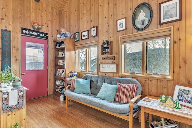 living area featuring light hardwood / wood-style floors, built in features, and wooden walls