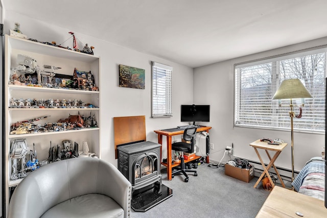 office area featuring carpet, plenty of natural light, a wood stove, and a baseboard heating unit