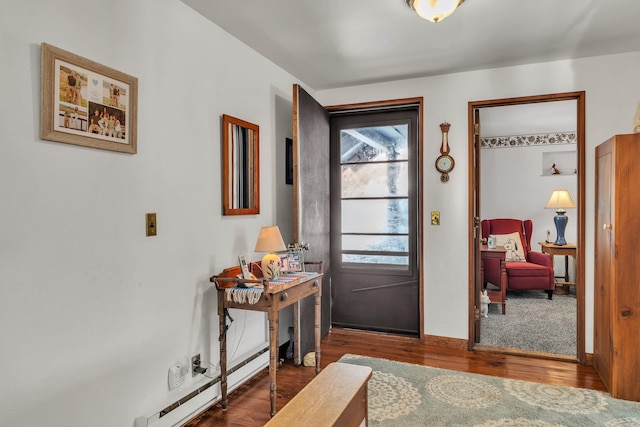 foyer entrance with wood-type flooring and a baseboard heating unit