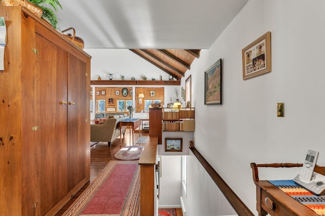 corridor with lofted ceiling with beams, wooden ceiling, and dark wood-type flooring