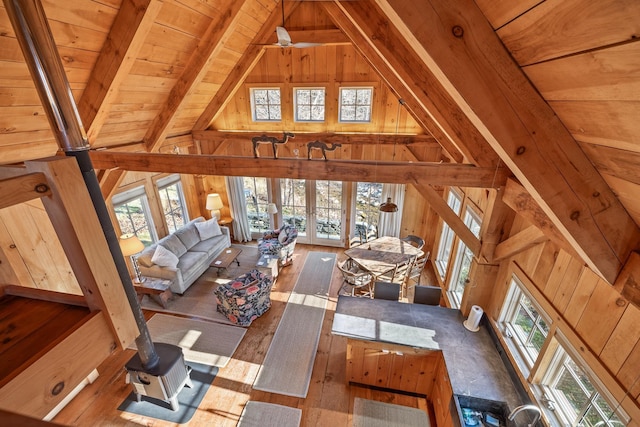 living room featuring wooden ceiling, wooden walls, hardwood / wood-style flooring, ceiling fan, and beam ceiling