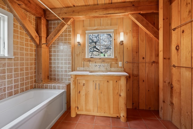 bathroom featuring wood walls, wooden ceiling, vanity, a tub, and tile patterned flooring