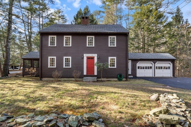 colonial house featuring a front yard and a garage