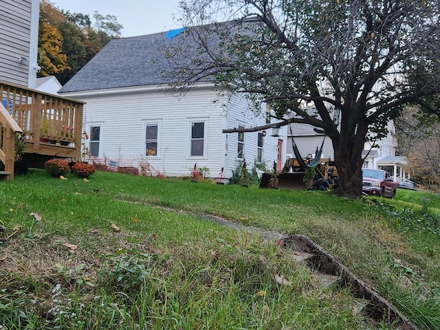 back of property with a yard and a wooden deck