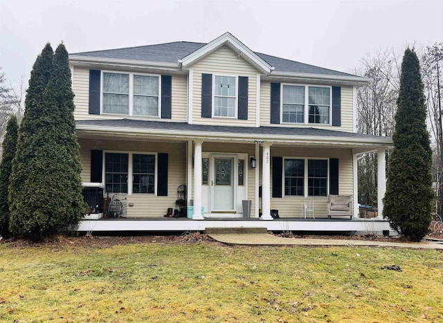 view of front of property with cooling unit, covered porch, and a front yard