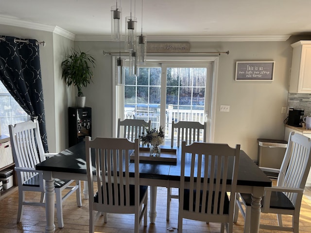 dining space with ornamental molding and light wood-type flooring