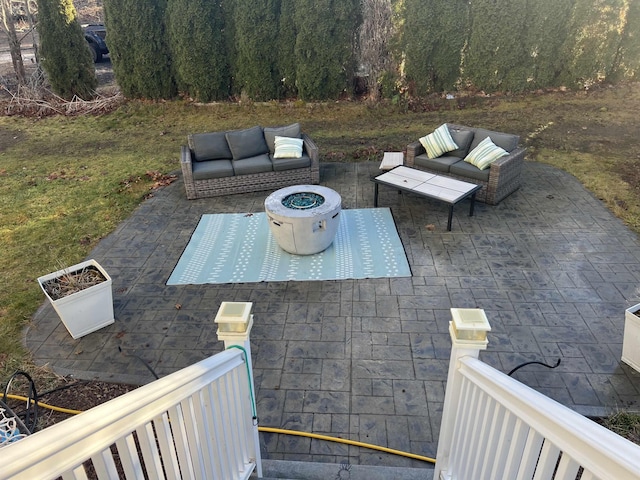 view of patio with an outdoor living space with a fire pit