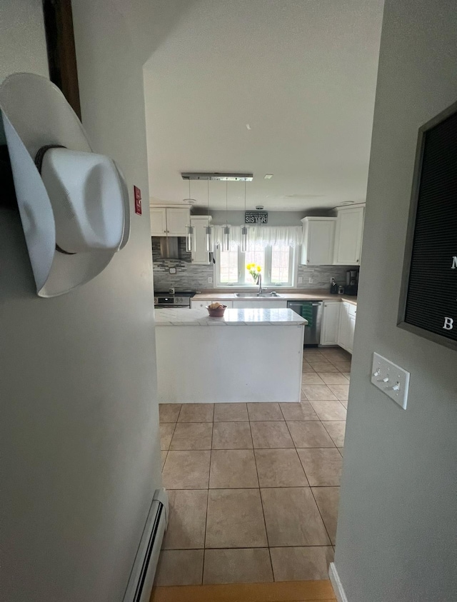 kitchen with white cabinetry, dishwasher, decorative backsplash, hanging light fixtures, and light tile patterned floors