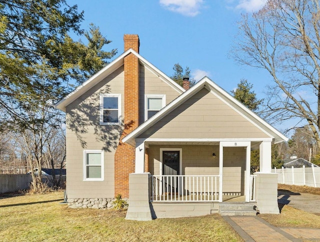 view of front of property with covered porch and a front yard