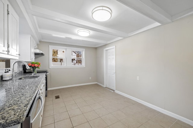 kitchen with stainless steel dishwasher, sink, dark stone countertops, white cabinets, and light tile patterned flooring