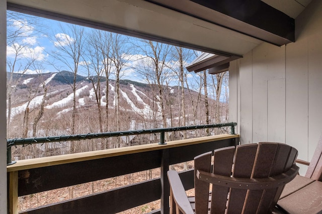 snow covered back of property with a mountain view