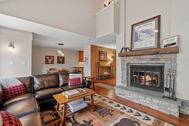 living room featuring hardwood / wood-style floors, wood walls, and a fireplace