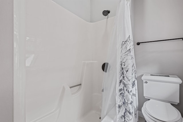 bathroom with a shower with shower curtain and toilet