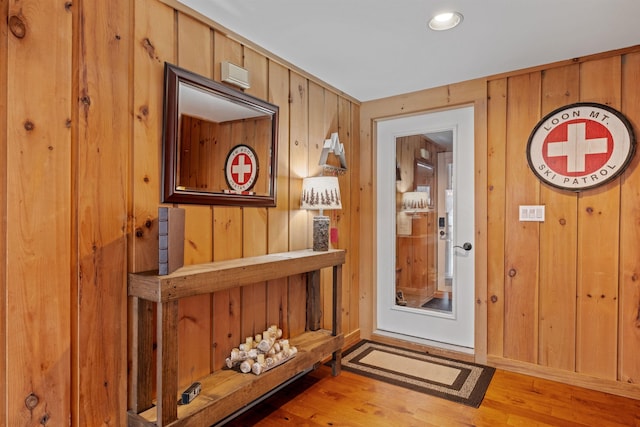 entryway with wood walls and light hardwood / wood-style floors