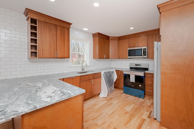 kitchen featuring kitchen peninsula, light stone countertops, range with electric cooktop, sink, and dishwasher