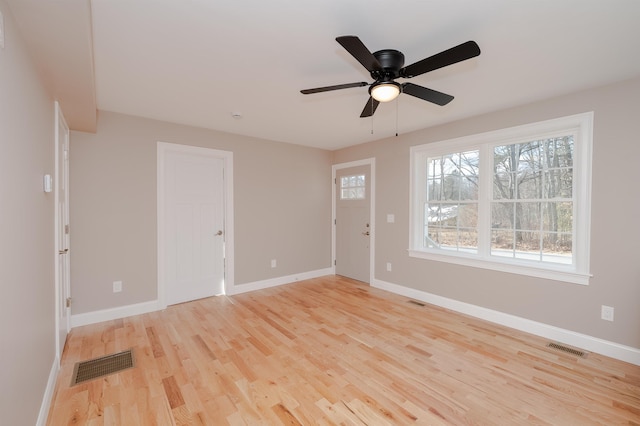 empty room with ceiling fan and light hardwood / wood-style floors