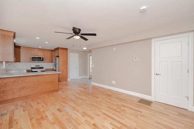 kitchen featuring ceiling fan, light hardwood / wood-style floors, sink, and stainless steel appliances