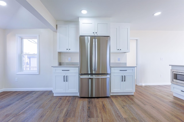 kitchen featuring appliances with stainless steel finishes, white cabinetry, and wood-type flooring