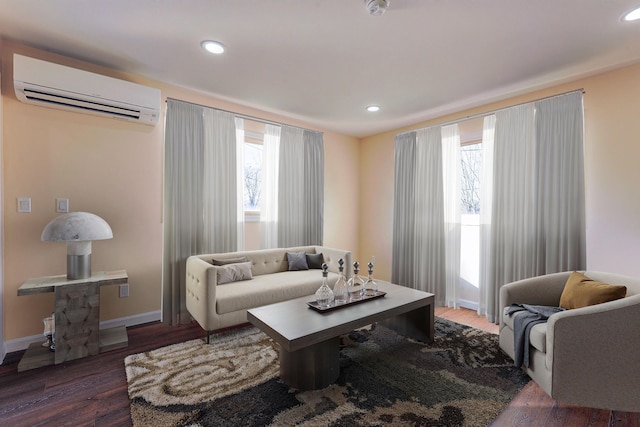 living room featuring a healthy amount of sunlight, dark wood-type flooring, and a wall mounted AC