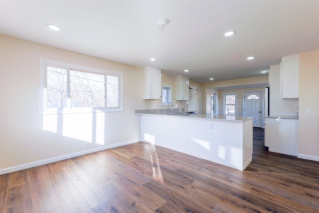 kitchen featuring kitchen peninsula, white cabinetry, dark hardwood / wood-style floors, and a wealth of natural light